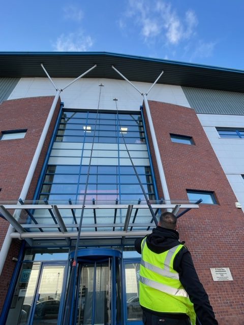 Man with long reach and wash pole for window cleaning