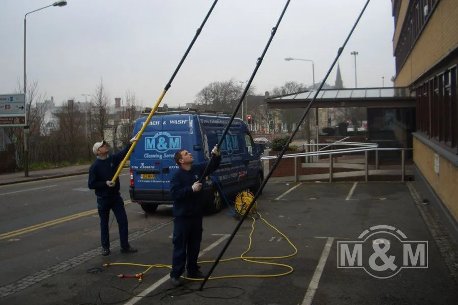 2 men using long reach and wash pole for window cleaning