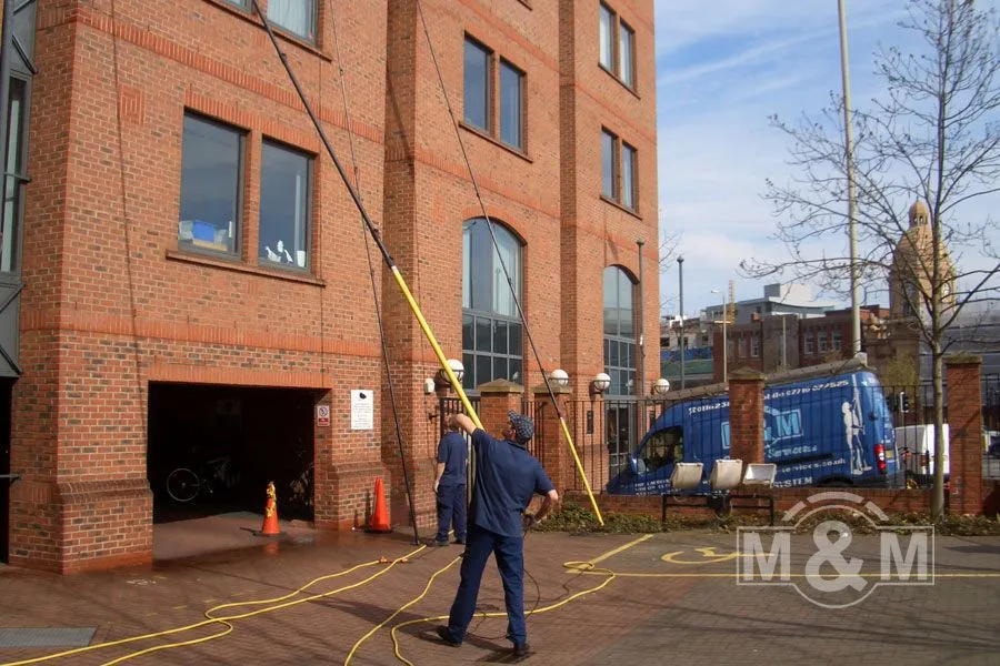 Man with long reach and wash pole for window cleaning